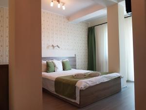 a bedroom with a large bed with green and white at Pensiunea Verde in Cluj-Napoca