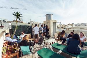 un grupo de personas sentadas en la azotea en Granny's Inn Hostel, en Sliema