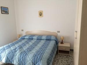 Schlafzimmer mit einem Bett mit blauer Decke in der Unterkunft Hotel Nuova Doel in Sottomarina