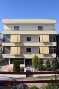 a tall white building with balconies on it at Haka Guesthouse in Golem