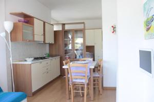 una cucina e una sala da pranzo con tavolo e sedie di Appartamento Stella Marina a Marcelli