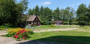 a house with a garden with flowers in front of it at Poilsio baze in Latežeris