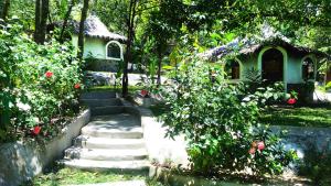 a garden with stairs leading to a house at Flower Power Farm Village in Ko Phayam