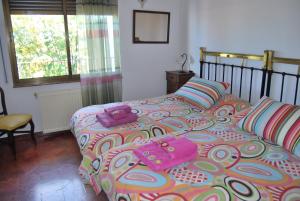ein Schlafzimmer mit einem großen Bett mit rosa Bettwäsche und Kissen in der Unterkunft Casa rural Puente Mocho in Ledesma