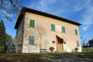 a building with green shutters and a bench in front at Villa Del Rimedio in Fucecchio
