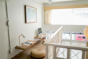 a room with a staircase with a desk and a television at Pakping Hostel in Chiang Mai