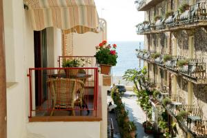 a balcony with a table and chairs on a building at Casa Putti in Letojanni