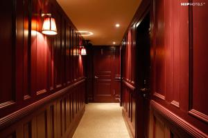 a hallway with red walls and a hallway with lights at Mimi's Hotel Soho in London