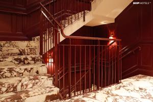 a spiral staircase in a building with red walls at Mimi's Hotel Soho in London