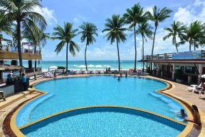 einen Pool am Strand mit Palmen und dem Meer in der Unterkunft Phangan Bayshore Resort Koh Phangan in Haad Rin
