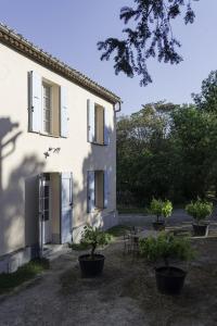 una casa blanca con macetas delante de ella en Domaine de La Forçate, en Villesiscle