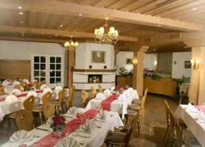 un salón de banquetes con mesas y sillas blancas y una lámpara de araña en Hotel & Restaurant Lamm, en Mosbach
