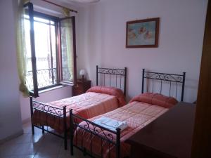アッシジにあるLe case di Tiberioのベッドルーム1室(ベッド2台、窓付)