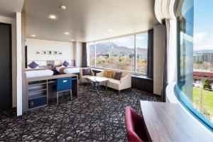 a hotel room with two beds and a desk at HOTEL MYSTAYS Sapporo Nakajima Park in Sapporo