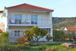 a house with two chairs on a balcony at Apartment Leonora in Vinišće