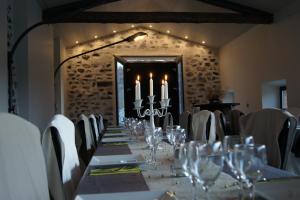 a long table in a room with white chairs and candles at Domaine de la Planche de Melussac in Cussac-sur-Loire +114 photos