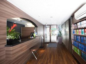an office lobby with a desk and bookshelves at FLEXSTAY INN Shinagawa in Tokyo