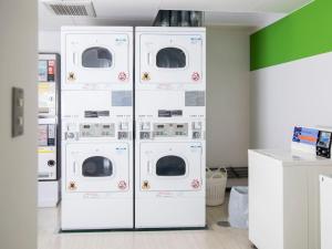 four washers and dryers are lined up in a room at FLEXSTAY INN Shinagawa in Tokyo
