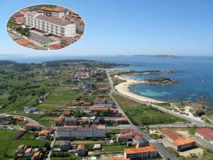- une vue aérienne sur la ville et l'océan dans l'établissement Hotel Con D´Arbon, à A Lanzada