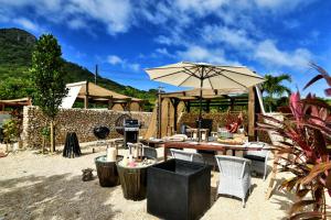 eine Terrasse mit einem Tisch und einem Sonnenschirm in der Unterkunft Glamping Resort Yokabushi in Ishigaki-jima