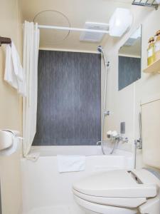 a white bathroom with a toilet and a sink at FLEXSTAY INN Shinagawa in Tokyo