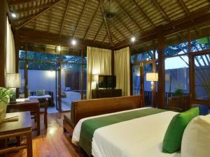 ein Schlafzimmer mit einem Bett, einem Schreibtisch und einem Fernseher in der Unterkunft The Quarter Pai in Pai
