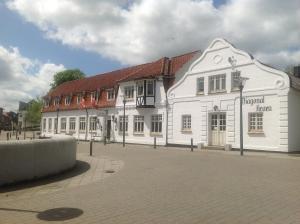 a white building with a red roof on a street at Diagonalkroen in Give