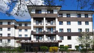 a large white building with a large window at Hotel Am Moosfeld in Munich