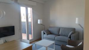 salon z kanapą i telewizorem w obiekcie Larramendi Terrace Apartment w mieście San Sebastián