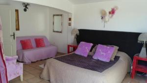 1 dormitorio con 1 cama con almohadas moradas y rosas en Mavilla, en Sainte-Maxime