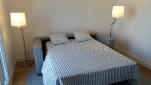 łóżko z 2 poduszkami w pokoju z 2 lampami w obiekcie Larramendi Terrace Apartment w mieście San Sebastián