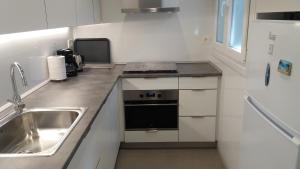 małą kuchnię ze zlewem i kuchenką w obiekcie Larramendi Terrace Apartment w mieście San Sebastián
