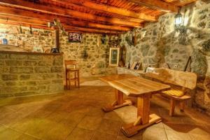 Pokój z drewnianym stołem i kamienną ścianą w obiekcie Holiday Getaway Caric w mieście Ivan Dolac