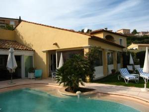 una casa con piscina frente a una casa en Mavilla, en Sainte-Maxime