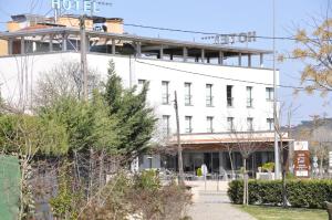 a white building with a sign on top of it at Hotel Palau de Girona in Sant Julià De Ramis