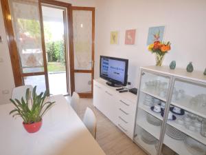 a dining room with a table and a tv and a table and chairs at SIT Holiday Homes in Lido delle Nazioni
