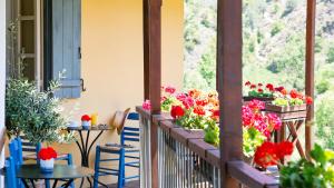a balcony with flowers and tables and chairs at Casale Panayiotis in Kalopanayiotis