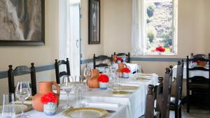 a dining room with a table with glasses and vases on it at Casale Panayiotis in Kalopanayiotis
