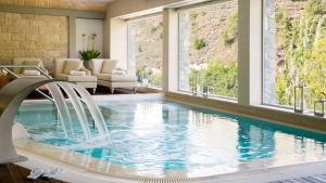 a swimming pool in a hotel room with windows at Casale Panayiotis in Kalopanayiotis
