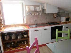 d'une cuisine avec des placards blancs, un évier et une fenêtre. dans l'établissement La Finestra sul Cielo, à San Benedetto del Tronto