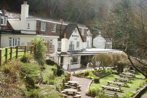 un grupo de mesas y bancos frente a un edificio en Royal Lodge en Symonds Yat