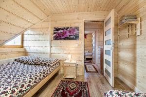 ホホウフにあるChocholowskie Domkiの木造キャビン内のベッドルーム1室(ベッド2台付)