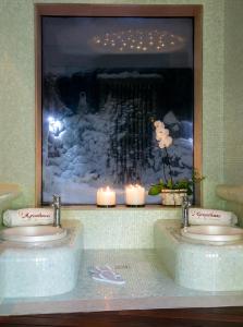 a bathroom with two sinks with candles and a picture at Casale Panayiotis in Kalopanayiotis