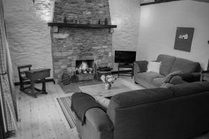 sala de estar con sofá y chimenea en The Bothy Self Catering Accommodation en Rousky