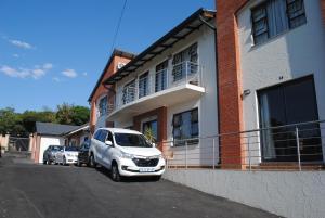 Un coche blanco aparcado delante de un edificio en 86 Edison Self Catering, en Johannesburgo