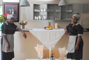 Dos chicas de pie en una cocina con un mostrador. en 86 Edison Self Catering, en Johannesburgo