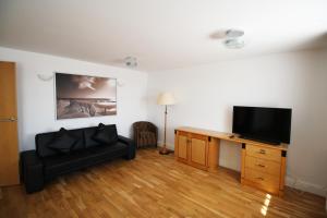 a living room with a couch and a desk with a television at Wellesley Road Apartments in Croydon