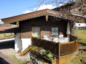 ein kleines Haus mit einer Veranda und einer Terrasse in der Unterkunft Gästehaus Rosi in Fieberbrunn