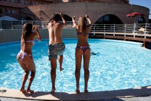 a group of people standing in a swimming pool at Club Esse Roccaruja in Stintino