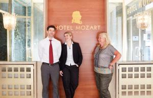 um homem e duas mulheres em pé em frente a um lobby de hotel em Hotel Mozart em Viena